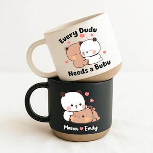 Peut inclure: Deux mugs en céramique empilés. Le mug supérieur est blanc avec une base marron et le texte "Every Dudu Needs a Bubu" avec un motif d'ours de dessin animé. Le mug inférieur est noir avec une base marron et les noms "Mason Emily" avec un motif d'ours de dessin animé.
