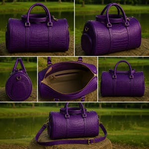 May include: A purple duffel bag with a textured crocodile skin pattern, featuring two top handles, a gold-toned zipper closure, and a detachable shoulder strap. The interior is lined with a light-colored fabric and includes a zippered pocket.