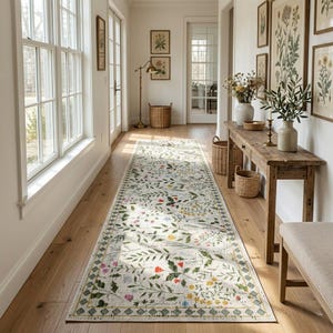 May include: A long, rectangular floral rug with a cream background and a border of green and gold geometric shapes. The rug features a pattern of colorful flowers and green leaves, adding a touch of nature to the hallway.