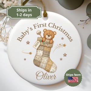 Pode incluir: Enfeite de Natal em cerâmica branca com fio dourado. O enfeite apresenta um ursinho de pelúcia numa meia com o texto "Baby's First Christmas" e o nome "Oliver". O ano de 2025 também é exibido.