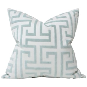 May include: A square throw pillow featuring a white base fabric with a raised, light blue velvet-textured Greek key geometric pattern. The design consists of interconnected lines forming a repeating maze-like motif across the entire surface.