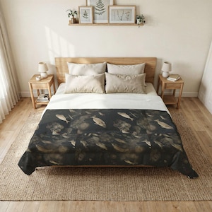 May include: A dark comforter featuring an abstract pattern of shapes and fish-like forms. The bed has a wooden frame, neutral pillows, and a white sheet. The room has wooden flooring and a neutral colour scheme. The comforter is suitable for a double bed.
