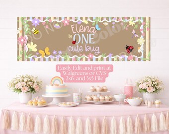 May include: A rectangular party banner featuring a brown center with the text Elena is ONE cute bug, surrounded by a border of colorful flowers, a bee, a butterfly, a dragonfly, and ladybugs against a background of vertical pastel stripes.