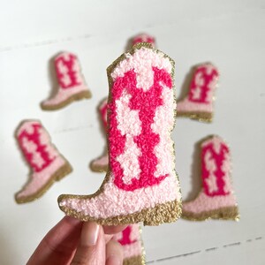 May include: Pink and red cowboy boot shaped felt patches with gold glitter trim.