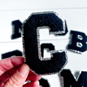 May include: Black felt letter C with a silver glitter trim. The letter is about 3 inches tall and is perfect for crafting projects.