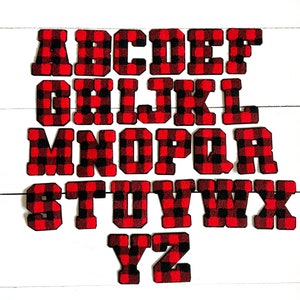 May include: A set of 26 felt letters in a red and black buffalo plaid pattern. The letters are uppercase and are arranged in alphabetical order.