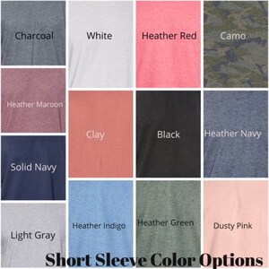 May include: A chart showing 12 different short sleeve t-shirt colors. The colors are: Charcoal, White, Heather Red, Camo, Heather Maroon, Clay, Black, Heather Navy, Solid Navy, Heather Indigo, Heather Green, and Dusty Pink. The text "Short Sleeve Color Options" is at the bottom of the chart.