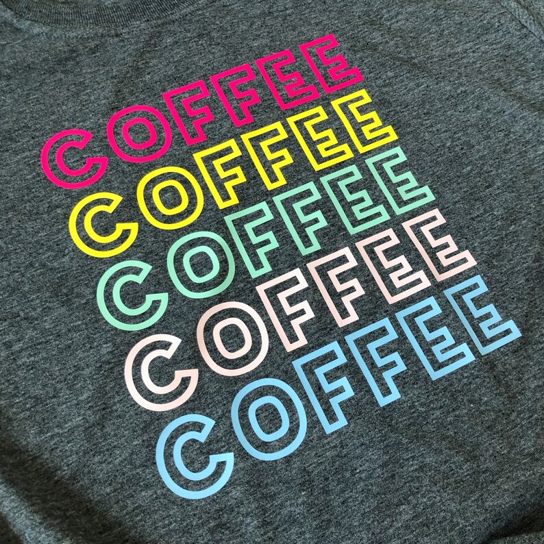 May include: A gray t-shirt with the word "COFFEE" repeated six times in a rainbow of colors, starting with pink and ending with light blue.