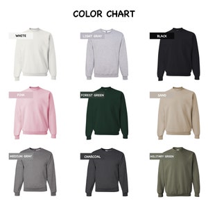 K&ouml;nnte beinhalten: Eine Farbkarte mit neun Sweatshirts mit Rundhalsausschnitt in verschiedenen Farben. Die Farben sind Wei&szlig;, Hellgrau, Schwarz, Rosa, Waldgr&uuml;n, Sand, Mittelgrau, Holzkohle und Milit&auml;rgr&uuml;n. Der Text "FARBKARTE" steht oben.