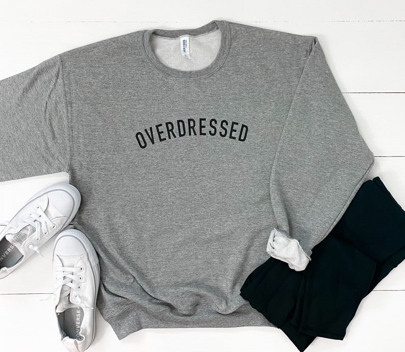 May include: Gray sweatshirt with the text "OVERDRESSED" printed in black on the front.
