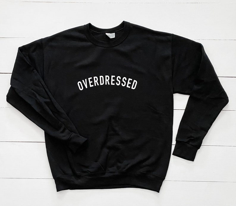 May include: Black sweatshirt with the text "OVERDRESSED" in white lettering.