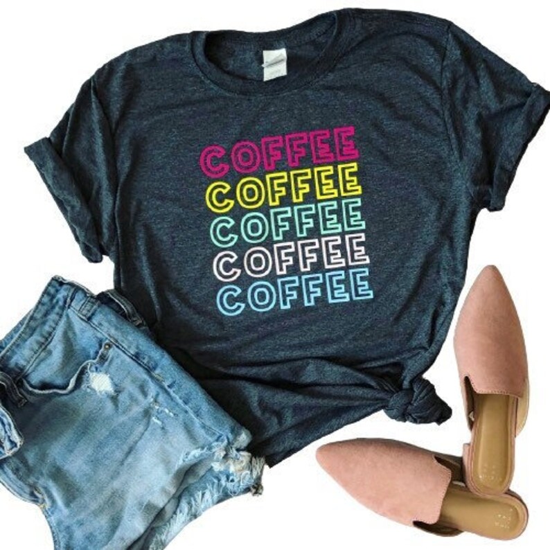 May include: A dark blue t-shirt with the word "COFFEE" repeated five times in a rainbow of colors. The text is in a retro, outlined font.