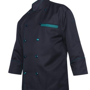 Könnte beinhalten: Eine dunkelmarineblaue Kochjacke mit zweireihiger Knopfleiste, passenden runden Knöpfen, Stehkragen und einem türkisfarbenen Akzentbesatz an Kragen, Ärmelbündchen und der einzelnen Brusttasche. Die langärmelige Jacke hat eine strukturierte Passform.