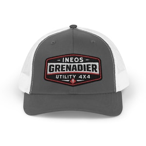 May include: A gray and white trucker hat with the text "- INEOS - GRENADIER UTILITY 4X4" embroidered on a black, red, and white patch. The hat has a curved brim and a mesh back.