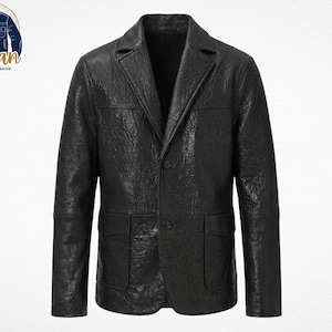 Puede incluir: Una blazer de cuero negro con un acabado texturizado. La chaqueta presenta solapas con muescas, dos bolsillos delanteros y cierre de dos botones. El logotipo de Urban Jacktery Shop está en la esquina superior izquierda.