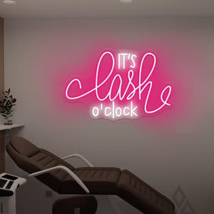 Puede incluir: Un letrero de neón rosa que dice "It's lash o'clock" cuelga de una pared blanca. Debajo, una silla de salón marrón con reposabrazos blancos. La habitación está iluminada con luces.