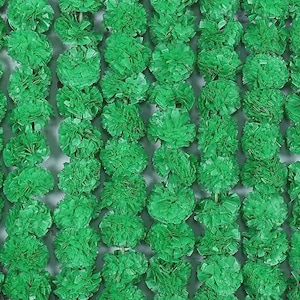 May include: Close-up of a vibrant green floral garland. The garland is composed of numerous, densely packed, round, textured flower-like elements. The overall effect is a lush, textured, and visually appealing display.