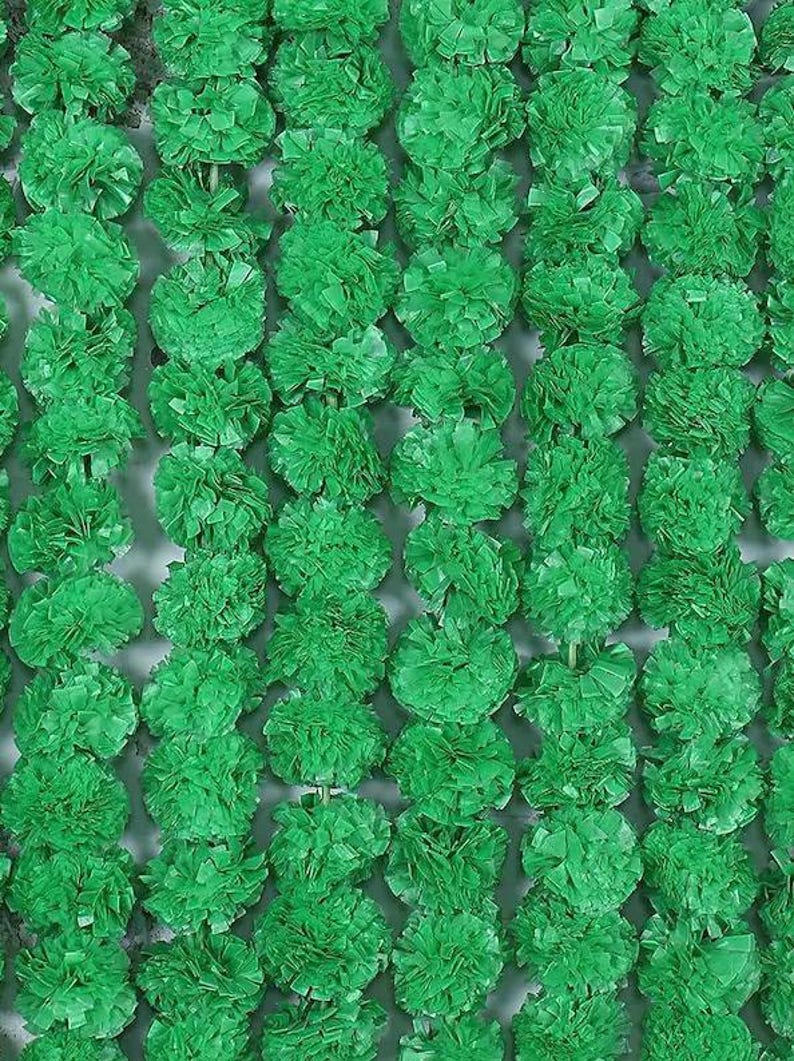 May include: Close-up of a vibrant green floral garland. The garland is composed of numerous, densely packed, round, textured flower-like elements. The overall effect is a lush, textured, and visually appealing display.