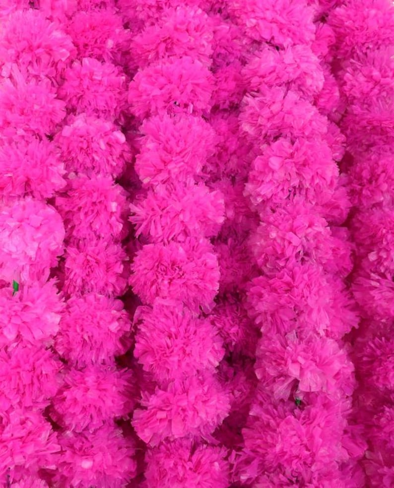 May include: Close-up of a vibrant display of bright pink, fluffy artificial flowers. The flowers are densely packed together, creating a textured, eye-catching background. The image showcases a floral arrangement, perfect for decorative purposes.