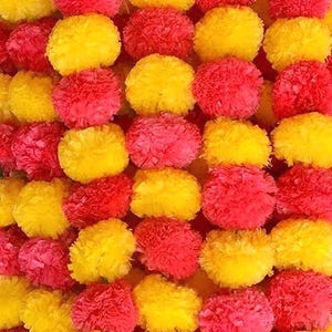 May include: Close-up of a vibrant garland composed of alternating rows of yellow and red pom-pom-like flowers. The flowers are densely packed, creating a textured and colorful display. The bright colors suggest a festive or decorative theme.