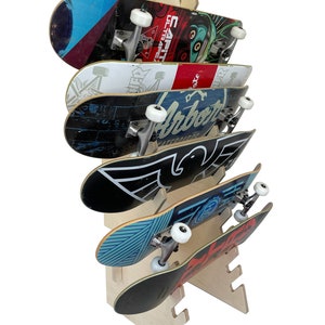 May include: A wooden skateboard rack with six skateboards displayed. The rack is made of natural wood and has a simple design. The skateboards are various colors and designs.