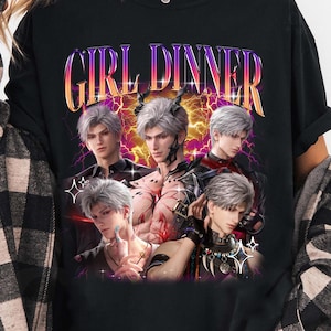 Può includere: T-shirt nera a maniche lunghe con la scritta "GIRL DINNER" in un font sfumato. La maglietta presenta una grafica di cinque personaggi in stile anime con capelli argentati. La grafica ha un design a fulmine viola e giallo.