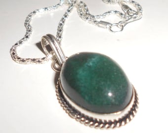 May include: A silver chain necklace with a green oval gemstone pendant. The pendant has a silver border with a decorative design.