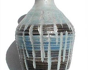 Może przedstawiać: Niebiesko-brązowy ceramiczny wazon z fakturowaną glazurą. Wazon ma wąską szyjkę i szerokie, zaokrąglone dno.