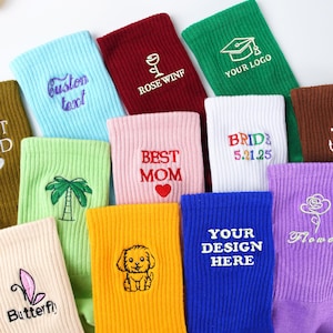 Könnte beinhalten: Eine Auswahl an farbenfrohen Socken mit gestickten Designs und Texten. Die Socken sind in verschiedenen Farben erhältlich, darunter Blau, Grün, Rosa und Gelb. Einige Socken zeigen Texte wie "Custom Text", "Rose Winf", "Best Mom" und "Your Design Here".