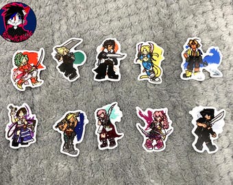 May include: A collection of colorful stickers featuring various anime-style characters, each holding weapons or in action poses. The stickers have white borders and are arranged on a gray, textured surface. A circular logo with a cartoon character is in the upper left corner.
