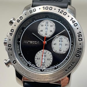 May include: A Seiko Albatrezza watch with a black dial, silver bezel, and black rubber strap. The watch features three sub-dials, red hands, and a tachymeter scale. The watch is marked with the text "ALBA JAPAN".