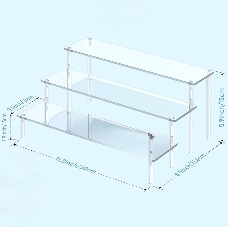 May include: A clear, three-tiered acrylic display stand. The stand is 11.8 inches (30 cm) long, 8.5 inches (21.6 cm) wide, and 5.9 inches (15 cm) tall. Each shelf is supported by clear legs, creating a floating effect. Ideal for showcasing small items.