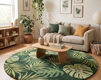 May include: A large, round area rug featuring a dense, repeating pattern of tropical palm and monstera leaves in various shades of dark and light green. The rug is positioned on a light-colored wooden floor in a living room setting.