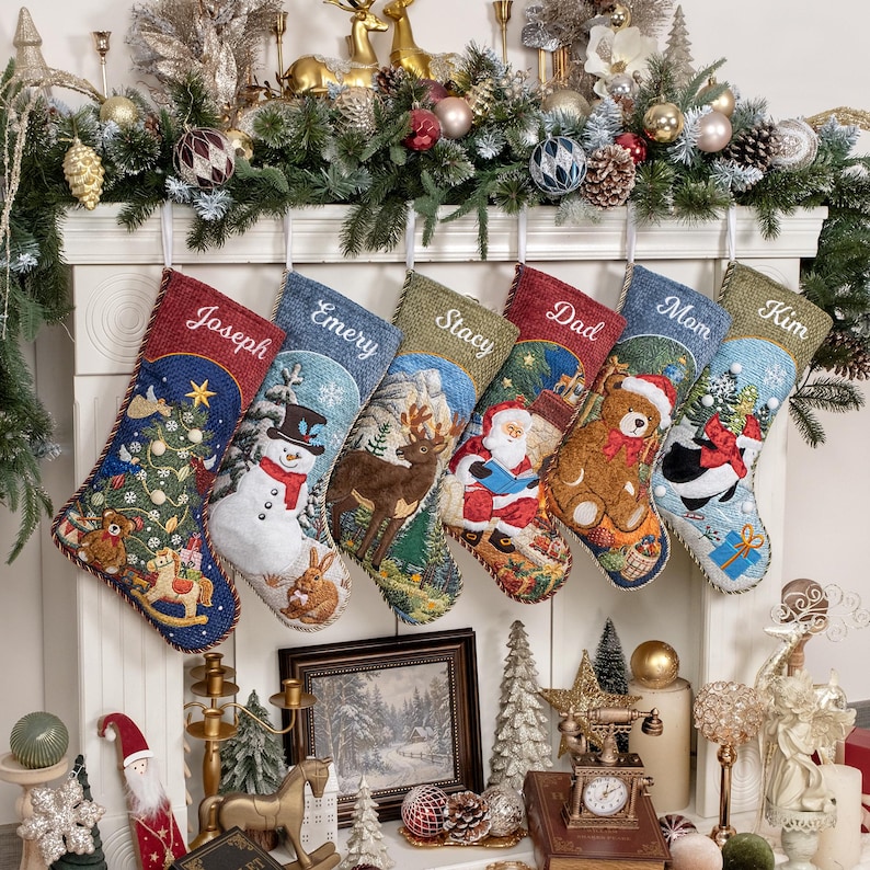 May include: Six personalized Christmas stockings hanging in a row, each featuring unique embroidered names: Joseph, Emery, Stacy, Dad, Mom, and Kim. The stockings display festive scenes including a snowman, reindeer, Santa, a teddy bear, and a penguin.