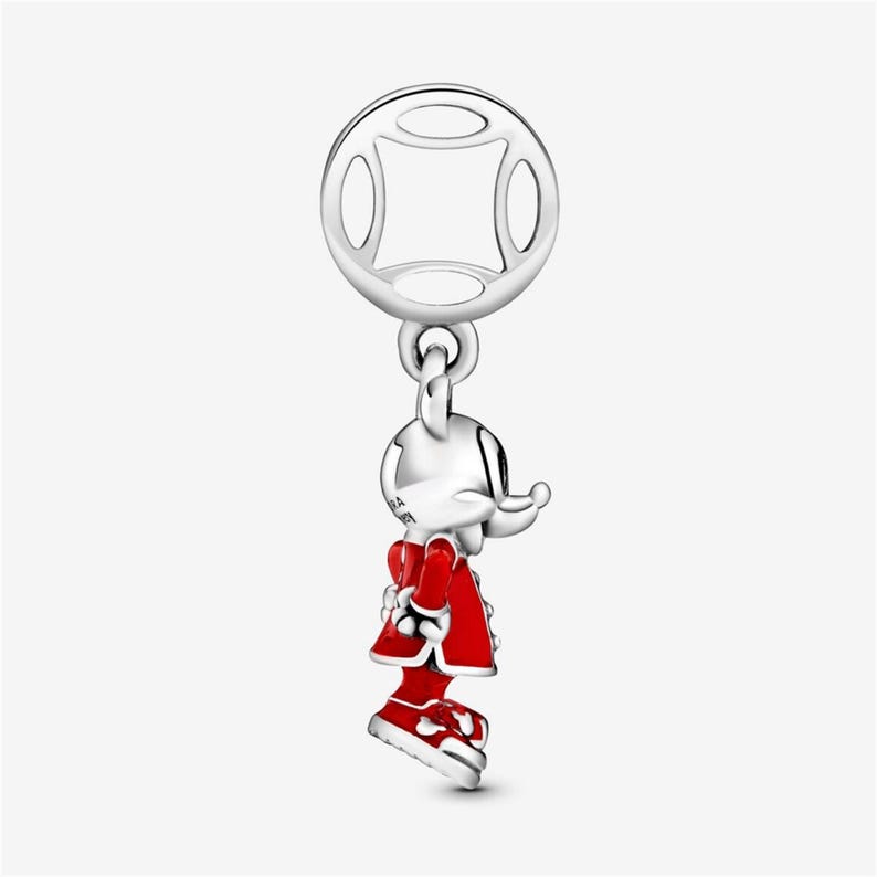 Puede incluir: Un charm de plata con un rat&oacute;n de dibujos animados con un atuendo rojo con detalles blancos. El charm tiene una parte superior circular con cuatro recortes ovalados y un peque&ntilde;o lazo que conecta con el rat&oacute;n. El rat&oacute;n lleva un abrigo y zapatos rojos.