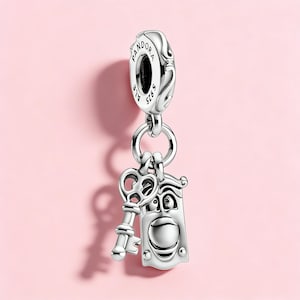 Puede incluir: Un charm de plata con un diseño de llave y aldaba. El charm está suspendido de una cuenta de plata más grande con la palabra "Pandora" grabada. La llave y la aldaba tienen diseños detallados.