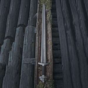 Handmade Viking sword with a Carbon steel blade and full tang design, featuring a detailed wave pattern. Comes with a custom hand-carved leather sheath, perfect for collectors or as a unique gift for men.