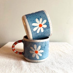 Handmade Lilac Ceramic Daisy Mug – Pottery Tea Cup with Orange Handle
