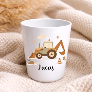 Puede incluir: Taza de cer&aacute;mica blanca con un dise&ntilde;o de excavadora de dibujos animados en tonos marr&oacute;n, beige y verde, con una nube, una estrella y una flor. El nombre "Lucas" est&aacute; escrito en cursiva negra debajo.