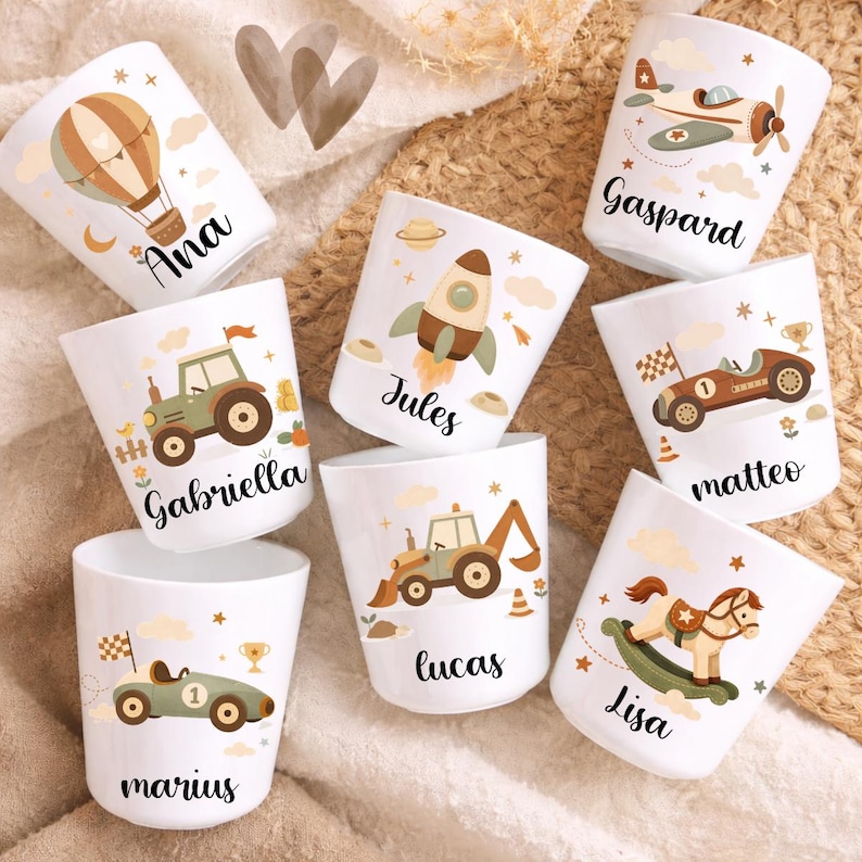 Puede incluir: Tazas de cer&aacute;mica blancas con ilustraciones coloridas de un globo aerost&aacute;tico, avi&oacute;n, cohete, coche de carreras, tractor y caballito balanc&iacute;n. Cada taza tiene un nombre: Ana, Gaspard, Jules, Matteo, Gabriella, Lucas, Marius y Lisa.