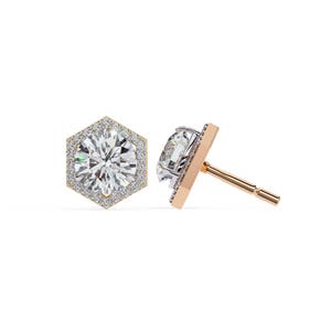 Peut inclure: Une paire de boucles d'oreilles à clous avec une grosse pierre précieuse ronde et transparente entourée de petites pierres précieuses transparentes dans un sertissage hexagonal doré. La tige est en or rose.