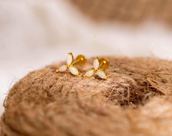 Puede incluir: Un par de pendientes de botón dorados con un diseño de flor de tres pétalos. Cada pendiente está engastado con tres ópalos blancos de talla marquesa dispuestos en racimo, creando una delicada forma floral con acabado en oro pulido.