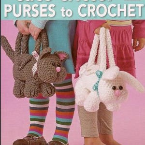 Puede incluir: Un libro de manualidades titulado cute critter PURSES to CROCHET que muestra dos bolsos de ganchillo con forma de animal. Uno es un gato marrón con nariz rosa y cinta de lunares blancos, el otro un conejo blanco con nariz rosa y cinta verde azulado.