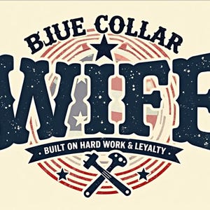 May include: A vintage-style graphic with the words "BLUE COLLAR WIFE" in navy blue, set against a cream background. The design includes a star, stripes, and the text "BUILT ON HARD WORK & LOYALTY" with crossed tools.
