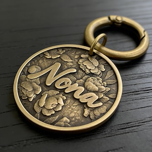 Op de afbeelding: Een witte keramische mok met een zwart handvat en de tekst "But First, Coffee" in een zwarte, handgeschreven lettertype. De mok staat op een wit oppervlak.