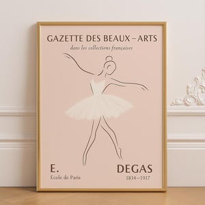 May include: Framed art print featuring a line drawing of a ballerina in a white tutu, set against a soft pink background. The print includes the text "GAZETTE DES BEAUX-ARTS" and "DEGAS 1834-1917". The artwork is in a gold frame.