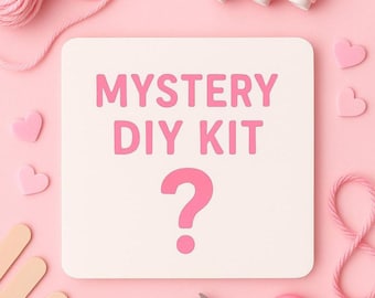 Könnte beinhalten: Ein rosa Bastelset mit dem Text "MYSTERY DIY KIT" und einem Fragezeichen. Das Bild zeigt rosa Garn, Garnrollen, herzförmige Dekorationen, Bastelstäbchen und eine Schere, alles auf rosa Hintergrund.