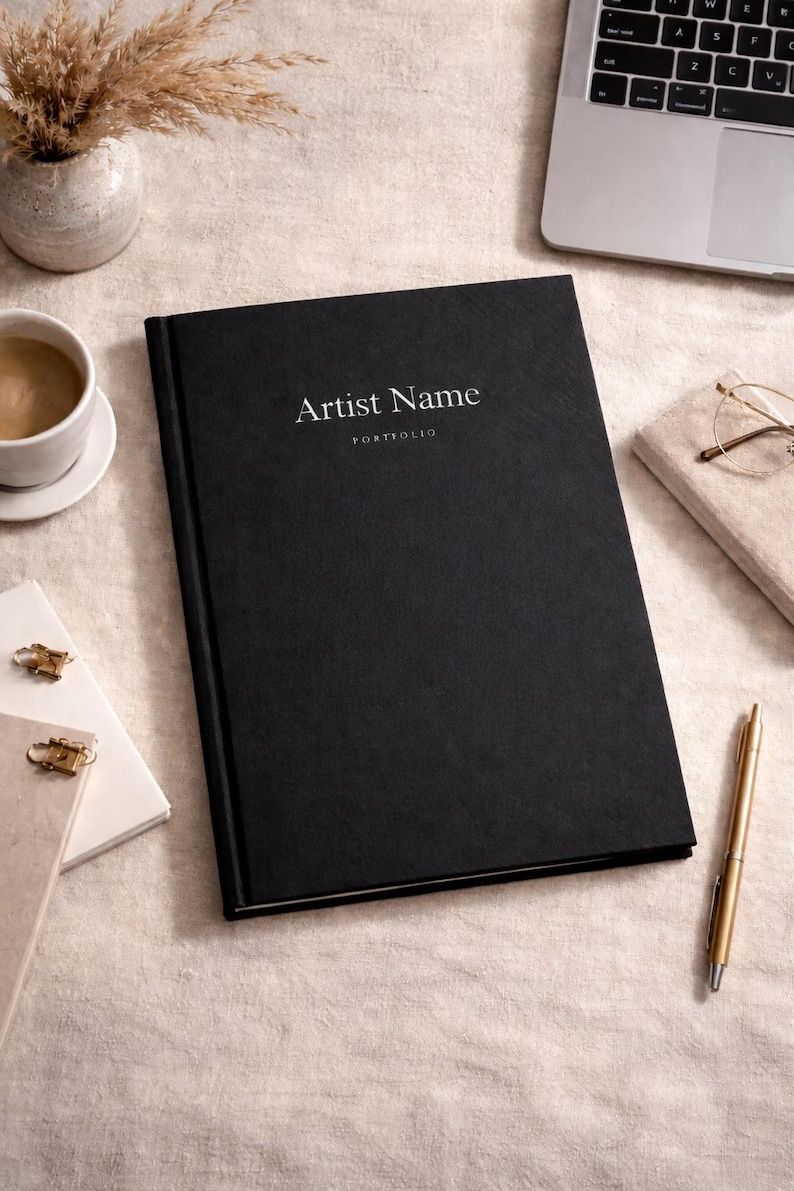 Pu&ograve; includere: Un portfolio con copertina rigida nera e il testo Artist Name e PORTFOLIO stampato in bianco sulla copertina anteriore. Il libro ha una finitura testurizzata ed &egrave; posizionato centralmente, con un design pulito per conservare opere d'arte.