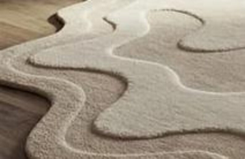 Pu&ograve; includere: Un tappeto beige di forma astratta con un design a strati. Il tappeto ha un aspetto morbido e strutturato, con diverse tonalit&agrave; di beige che creano un effetto dimensionale. I bordi del tappeto hanno una forma fluida e organica, che aggiunge alla sua estetica moderna.