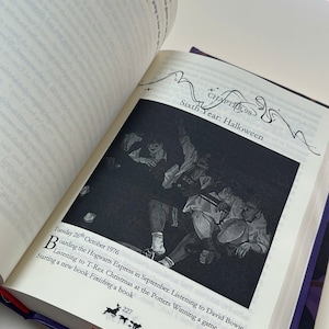 May include: An open book with a black and white illustration of a group of people. The text reads "Sixth Year: Halloween" and "Tuesday 26th October 1976". A red ribbon bookmark is visible.